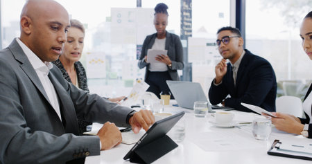 Tablet, planning and teamwork with business people in meeting for revenue, profit report and research. Budget proposal, investment portfolio and feedback with employees in office for projectの写真素材