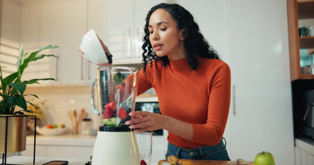Fruit, blender and woman with smoothie in kitchen for health, wellness or breakfast in home. Morning, nutrition and female person with ingredients for vitamins, organic or shake for diet in house.の写真素材