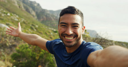 Selfie, hiking and happy man in nature for vacation, POV and travel influencer show mountain. Asian person, portrait and profile picture for trekking, adventure and photo for social media in Cambodiaの写真素材