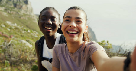Women, friends and selfie for hiking, smile and portrait on mountain, live stream or excited in nature. Girl, happy and photography for memory, profile picture or outdoor on social media for trekkingの写真素材