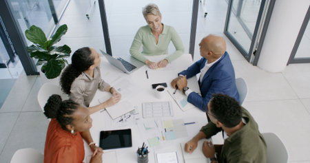 Top view, finance paperwork or business people in office for development, planning or teamwork. Talking, document or financial analysts in meeting for solution, brainstorming or collaboration projectの写真素材