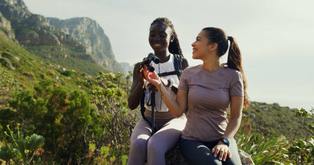Smile, people and friends with binocular for hiking, nature sightseeing and mountain view. Happy, women and relax for travel, backpacking adventure and birdwatching observation with wildlife searchの写真素材