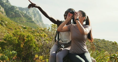 Happy, women and friends with binocular for hiking, nature sightseeing and mountain view. Smile,...