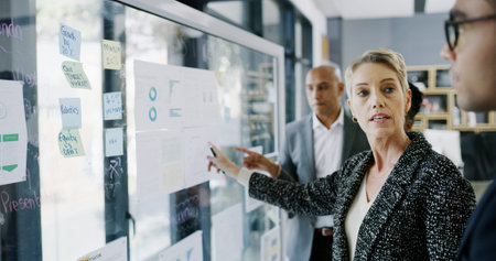 Documents, pointing and manager with business people in meeting for research, data chart and sales...