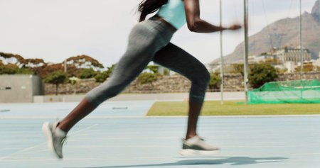 Woman, race and running with legs on stadium track for speed, motion or sprint. Female person,...