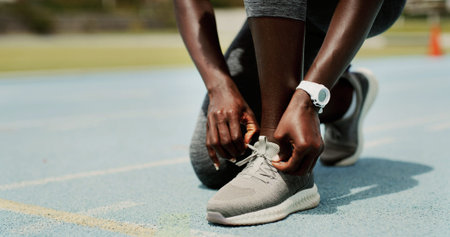 Sports, shoes and hands of person on track for running, workout or training for race outdoor....