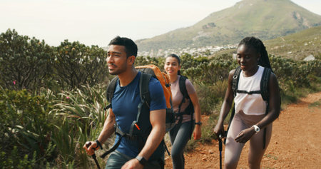 Friends, people and hiking in nature for travel, holiday or group walking on vacation together. Man, women and outdoor with trekking pole for adventure, expedition or explore mountain path on journeyの写真素材