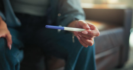 Hands, woman and check pregnancy test at house of fertility results, information and maternity news. Person, waiting and reading stick of family planning, pregnant confirmation and conception outcomeの写真素材