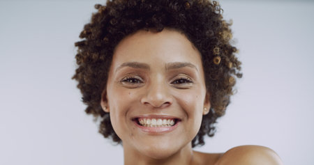 Afro, portrait and smile of woman in studio for natural cosmetics or dermatology results. Aesthetic, beauty and teeth with happy model isolated on white background for cosmetology or skincareの写真素材