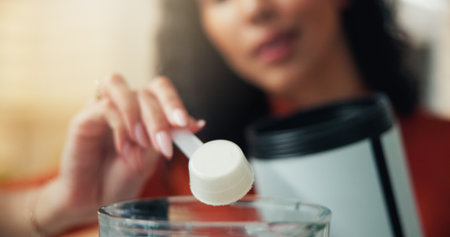Scoop, nutrition and hands with supplement, home and preparing protein shake, healthy and vitamin C. Self care, wellness and woman with powder ingredient for detox benefits, diet and fiber in houseの写真素材
