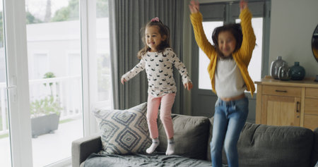 Jumping, energy and ADHD with kids on sofa for hyperactivity, playful and bonding. Sensory...