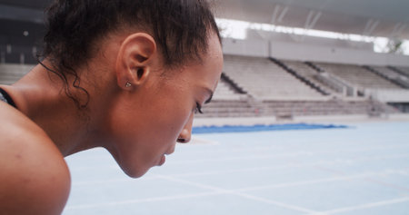 Breathe, rest and woman in stadium for fitness, workout and training for race or competition. Sports arena, athlete and person with fatigue, tired and recovery for running, exercise and practiceの写真素材