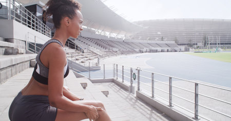 Sports, woman and knee pain with injury at race track, fitness accident and thinking. Runner, stadium and athlete with sore legs with muscle sprain, joint inflammation or reflection for arthritisの写真素材