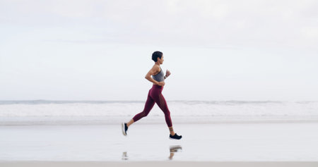 Woman, running and fitness at beach, shore or training with space, sky or outdoor for routine....