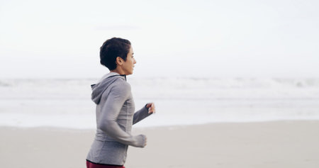 Running, ocean and fitness with woman at beach for health, cardio workout and sports training....