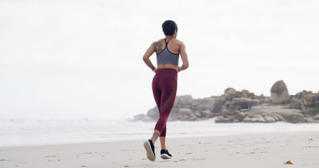 Back of woman, workout and run on beach for fitness, exercise or outdoor wellness. Female person,...
