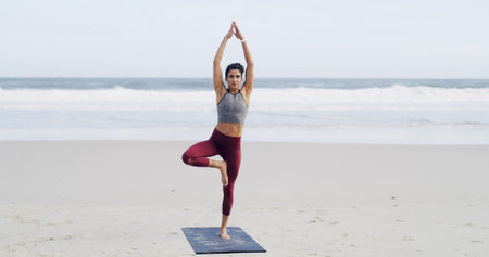 Woman, yoga and tree pose at beach with balance, mindfulness and breathing exercise in nature....