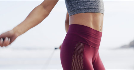 Body, fitness and skipping with woman on beach for cardio training or sports workout in morning....