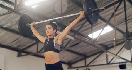 Weightlifting, barbell and fitness with woman in gym for workout, muscle development or health. Bodybuilder, wellness and core strength with person in sports center for exercise and challengeの写真素材