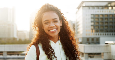 Portrait, happy girl and university student in city for education, learning or scholarship. Smile, learner and woman at college campus outdoor with morning flare, development or opportunity in Brazilの写真素材