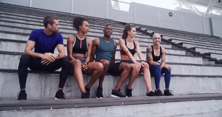 Conversation, break and fitness with friends on venue bleachers for bonding or sports training....