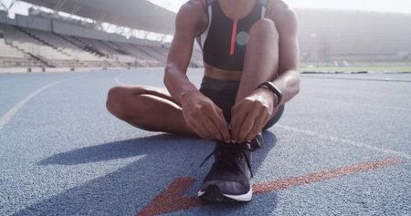 Athlete, hands and tie shoes on track for marathon practice, running comfort and start race workout....
