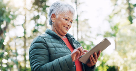 Nature, happy and senior woman with tablet for texting, communication or mobile app for weekend...