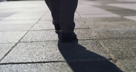 City, legs and business person walk for travel, urban journey or morning commute on sidewalk. Back, shoes and worker on street outdoor with professional, pedestrian and trip for corporate career pathの写真素材