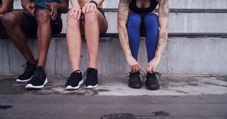 Fitness, hands or people tie shoes at stadium to prepare for exercise with friends outdoor for...