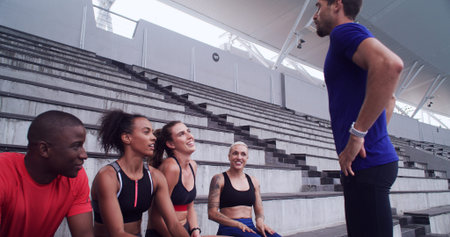 Runner, coach and team with people on stadium steps for workout break, fitness and support....