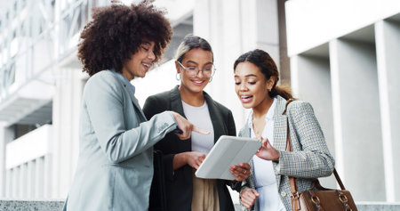 Discussion, tablet and business women in town with research for finance negotiation in collaboration. Conversation, digital technology and team of female financial advisors with investment planning.の写真素材
