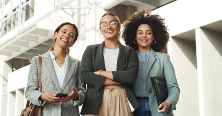 Happy, crossed arms and portrait of business women in city with confidence for finance career. Smile, teamwork and group of female financial advisors with pride for corporate job in urban town.の写真素材
