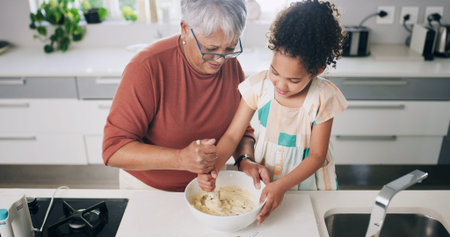Baking, dough and grandma with child in kitchen for learning, teaching and helping for cookies. Family, above and grandmother with girl with flour, ingredients and bonding for dessert, cake or pastryの写真素材