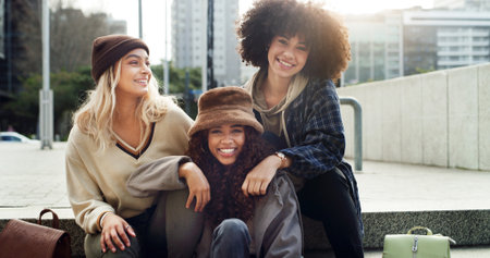 Happy, city and portrait of girl friends on stairs with fashion for trendy, cool and clothes on holiday. Smile, steps and female people with stylish outfit in urban town on vacation or weekend trip.の写真素材