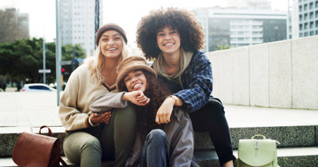 Portrait, happy and girl friends on stairs with fashion for trendy, cool and modern clothes on holiday. Smile, steps and female people with stylish outfit in urban town on vacation or weekend trip.の写真素材