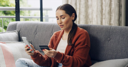 Credit card, ecommerce and phone with woman on sofa in living room of home for checkout. App, online...