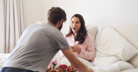 Surprise, love and couple with breakfast in bed for anniversary, romance or weekend break together....