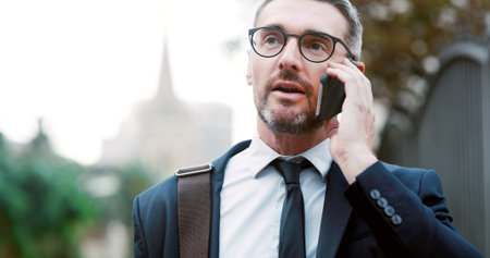 Phone call, walking and businessman in city with communication, networking or contact for deal. Talking, cellphone and male financial manager on mobile discussion for finance negotiation in town.の写真素材