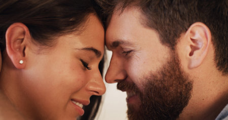 Love, romance and trust with forehead of couple closeup together for connection or safety. Bonding, security or smile with man and woman in moment for honeymoon, marriage anniversary or wellnessの写真素材