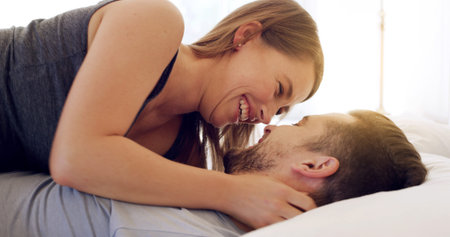 Happy, couple and relax with romance on bed for healthy relationship, weekend break and connection....