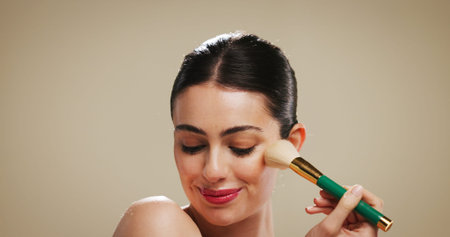 Cosmetics, makeup and brush with woman in studio for blush, beauty and foundation application....