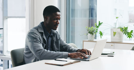 Black man, typing and office with laptop for business report, project planning or company research....