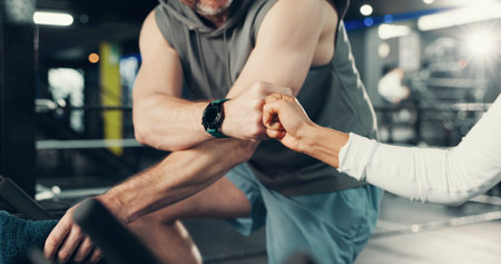 Fitness, hands and fist bump on stationary bike at gym for cardio challenge, training or support....