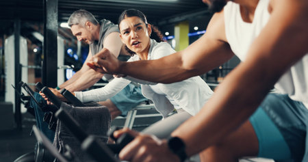 Fitness, people and fist bump on stationary bike at gym for cardio challenge, training or support....