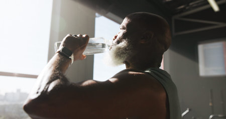 Fitness, exercise and man with drinking water at gym for hydration, workout recovery and resting....