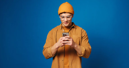 Phone, glasses and scroll with man in studio for social media, networking and connection. Mockup...