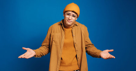Man, portrait and student with shrug in studio, question or dont know for academic future or choice...