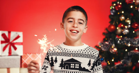 Portrait, child and boy with sparkler, Christmas or celebration for festive season or red...