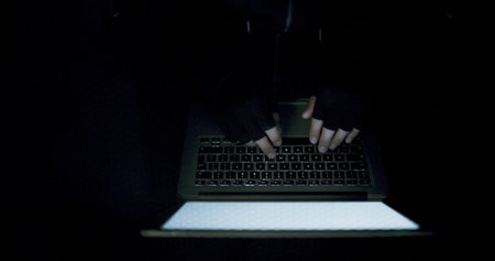 Night, hacking and hands of person on laptop from above in cyber crime, internet fraud or malware....
