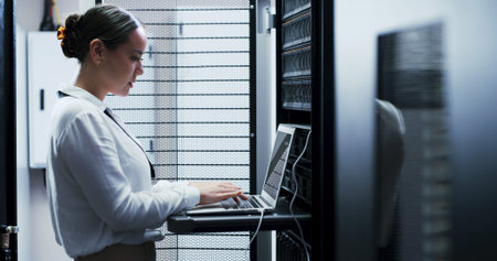 Laptop, typing and woman in server room for cybersecurity, network maintenance or programming....